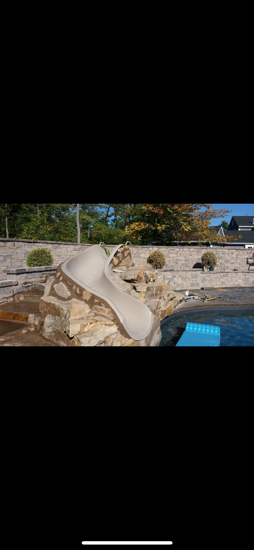 Custom pool waterfall and slide with natural stone